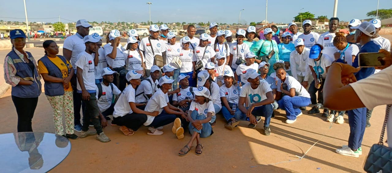 Grande grupo de voluntários da Mesu a Kikwambi, com boné da associação, numa acção ao ar livre